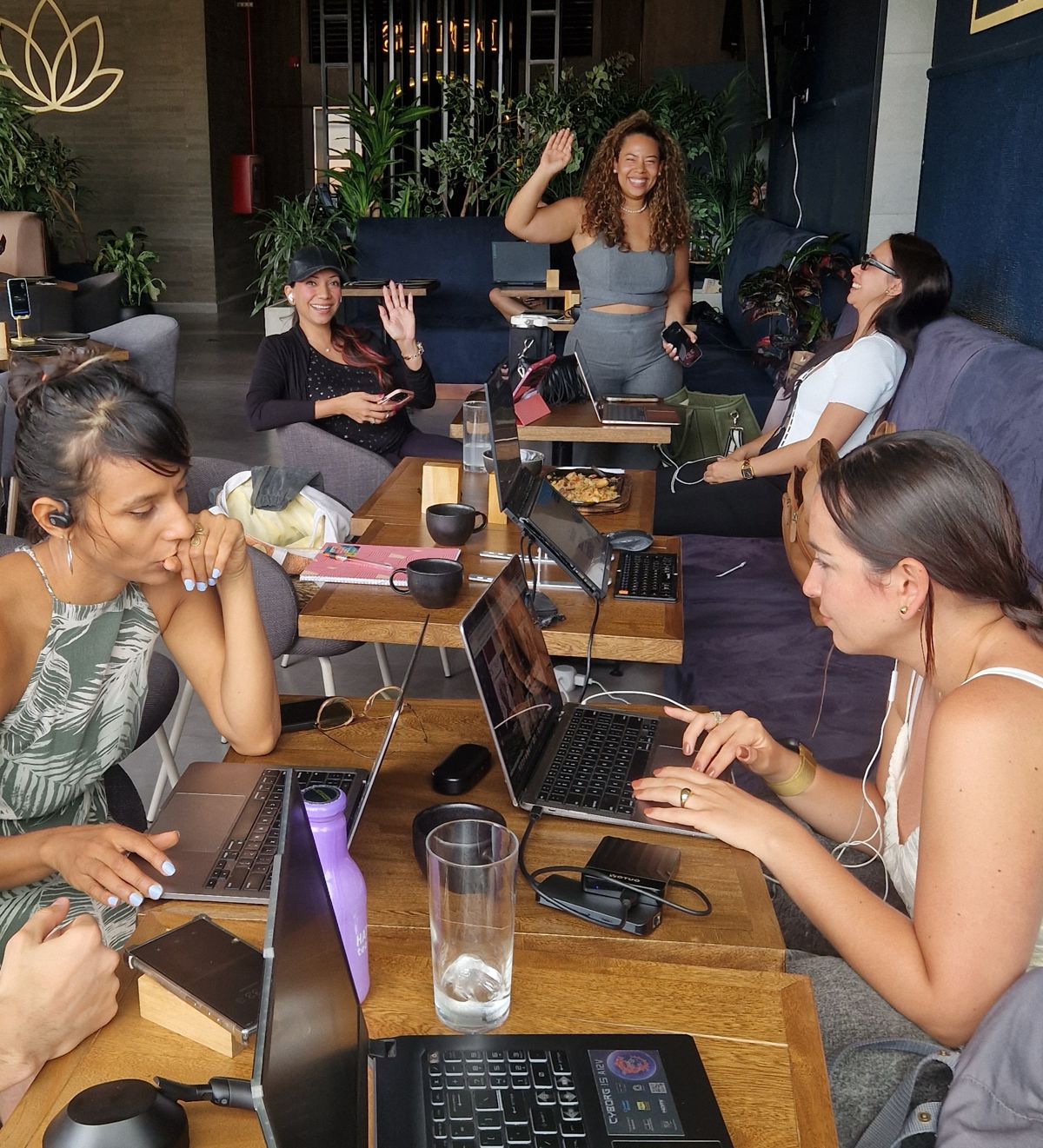 Humans v Robots builders working on laptops together around a café table